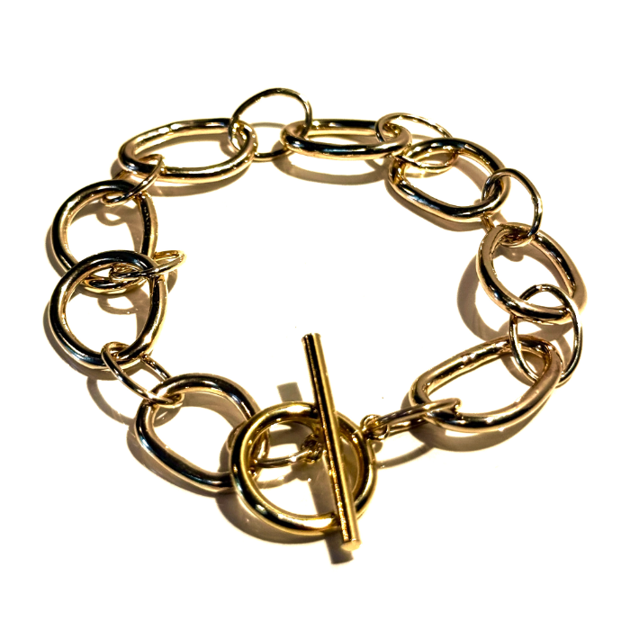 A gold chain bracelet with thick interlocking oval links and a toggle clasp, photographed on a plain white background.